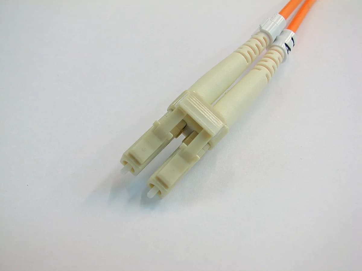 Connecteur fibre optique LC beige sur fond blanc